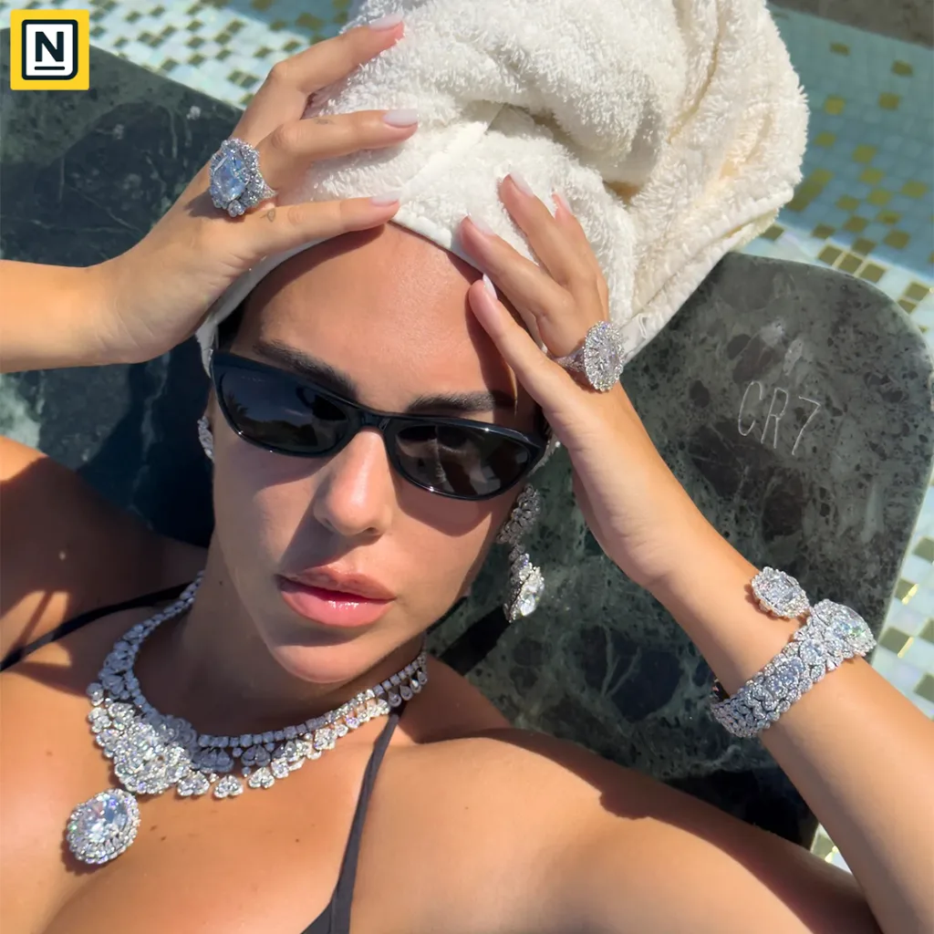 Georgina Rodríguez wearing dazzling diamond jewellery, including a necklace, earrings, rings, and bracelets, while relaxing by a pool.